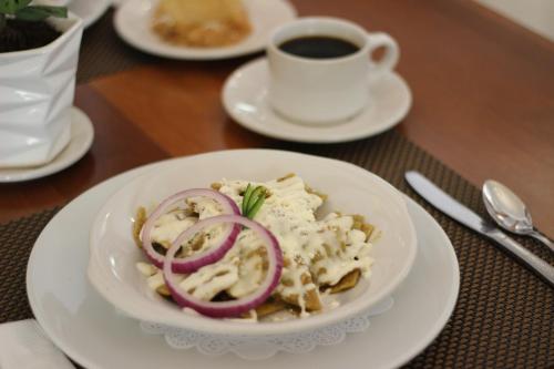 a plate of food on a table with a cup of coffee at Hotel de Mendoza in Guadalajara