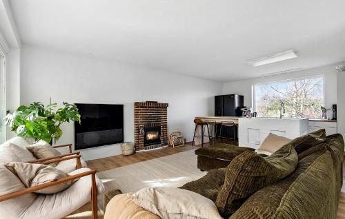 a living room with a couch and a fireplace at 5 Bedroom Beautiful Home In Gilleleje in Gilleleje