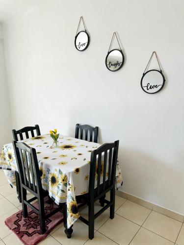 a dining room table with four chairs and a white wall at Easy stay in Kashari