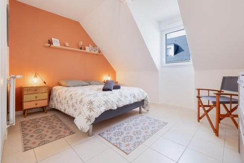 une chambre avec un lit avec un mur orange dans l'établissement Séjour Confort Mer & Littoral LE CROISIC, au Croisic
