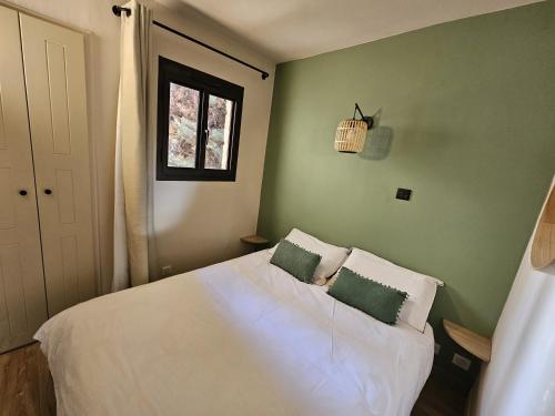 une chambre avec un lit blanc avec deux oreillers dans l'établissement Appartement Le Riviera, à Cannes