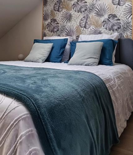 Elle comprend un grand lit avec des draps et des oreillers bleus et blancs. dans l'établissement L'Elitys with Parking - Reims-Hypercentre, à Reims