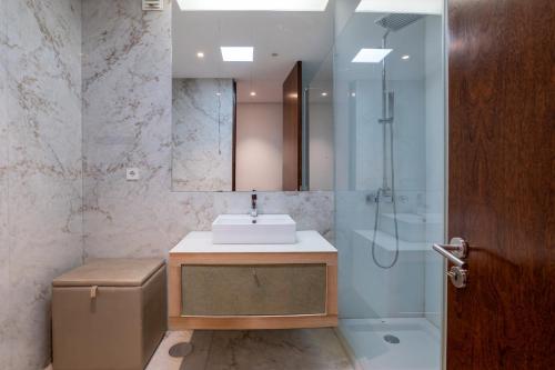 um banheiro com pia e chuveiro em The Povoa Villa na Póvoa do Varzim