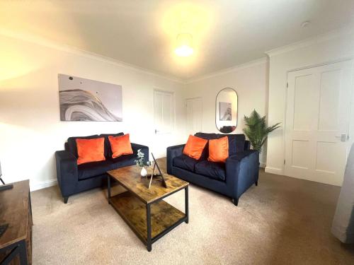 a living room with two blue couches and a table at The Billingham House By Blue Skies Stays in Stockton-on-Tees
