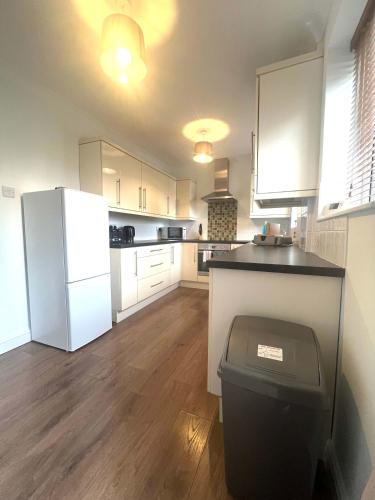 a kitchen with a white refrigerator and a trash can at The Billingham House By Blue Skies Stays in Stockton-on-Tees