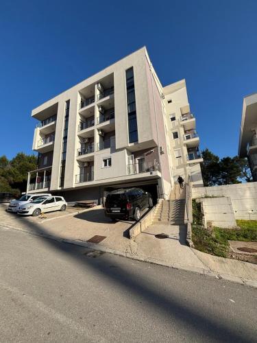 a large building with cars parked in front of it at Aerodrom Appartment ''Ana'' in Tivat