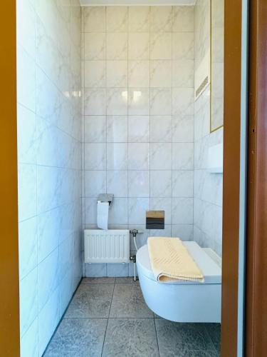 a white bathroom with a tub and a toilet at E&C Pension Rooms in Vienna