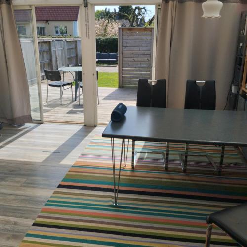 a table and chairs in a room with a rug at Privat gästhus med egen trädgård in Kävlinge