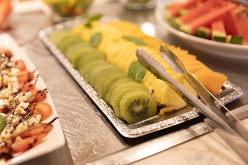 a plate of food on a table with fruit at Hotel Pinzger Tux in Tux