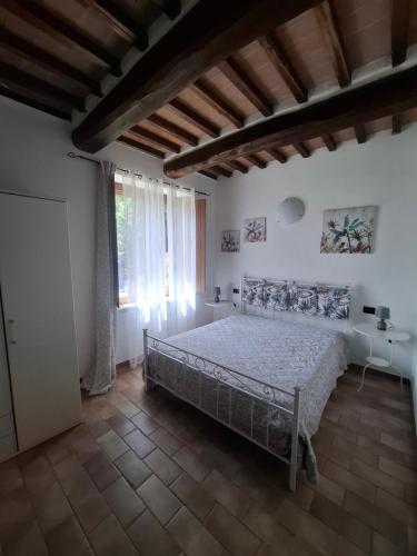 a bedroom with a bed and a large window at Agriturismo e Glamping Serraiola Alta in Frassine