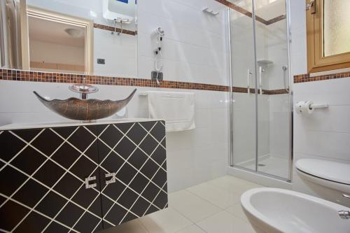 a bathroom with a sink and a glass shower at Residence & Bed e Breakfast AlaMarina in Peschici