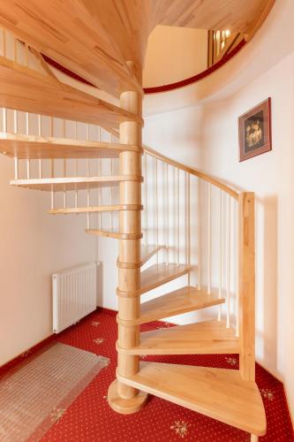 a spiral staircase in a house with a red carpet at Hotel Pinzger Tux in Tux