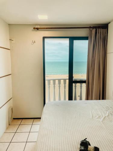 a bedroom with a bed and a view of the beach at Classic Residence in Fortaleza