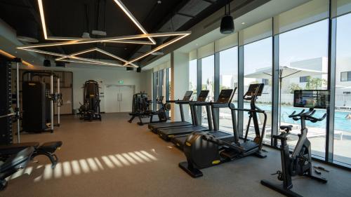 a gym with treadmills and ellipticals and a pool at 4br Luxury Villa Yas Island Near F1 in Abu Dhabi