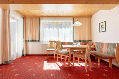 a dining room with a table and chairs at Hotel Pinzger Tux in Tux