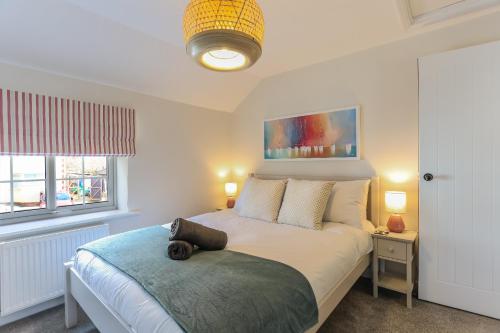 ein Schlafzimmer mit einem Bett und einem Kissen darauf in der Unterkunft Wallaby - East Wittering Fisherman's Cottage in East Wittering