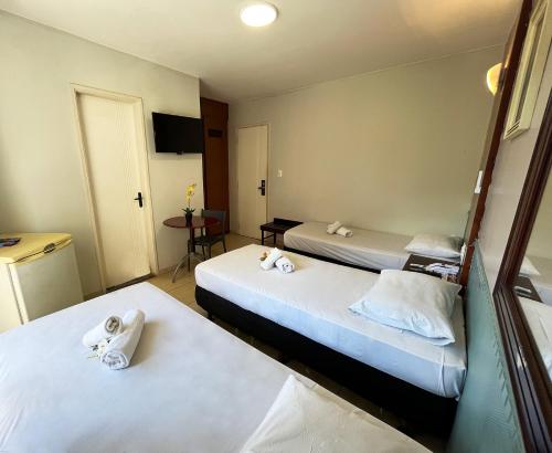 a room with two beds with towels on them at Hotel Alvorada Taguatinga by Bsb Inn in Taguatinga