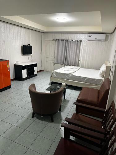 a room with a bedroom with a bed and a couch at MAGNIFICo INN PATTAYA in Pattaya