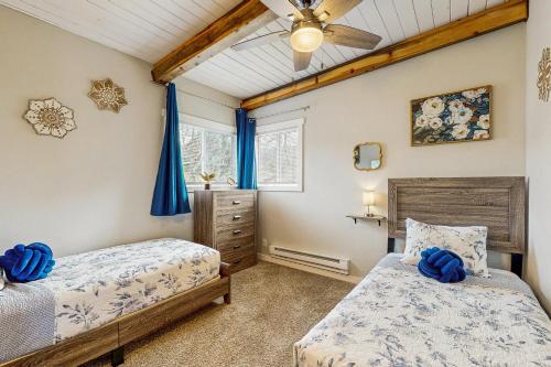 a bedroom with two beds and a ceiling fan at Elli's Haus in Rockaway Beach
