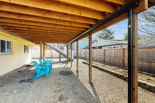 a group of blue benches sitting under a building at Elli's Haus in Rockaway Beach