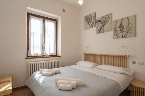 a bedroom with a bed with two towels on it at Il Giardino delle Tre Veneri in Barzio