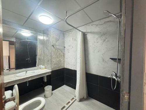 a bathroom with a shower and a sink and a toilet at Jomtien Longstay Hotel - SHA Plus Certified in Jomtien Beach