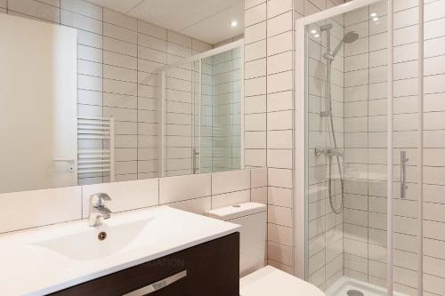 une salle de bain blanche avec un lavabo et une douche dans l'établissement Residence Aout 32, à Cannes