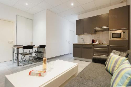 un salon avec un canapé et une cuisine dans l'établissement Residence Aout 12, à Cannes