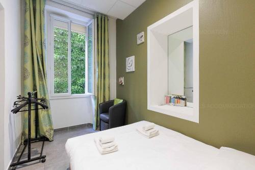 Cette chambre comprend un lit, un miroir et une chaise. dans l'établissement Residence Aout 12, à Cannes
