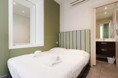 une chambre avec un lit avec deux serviettes dessus dans l'établissement Residence Aout 22, à Cannes