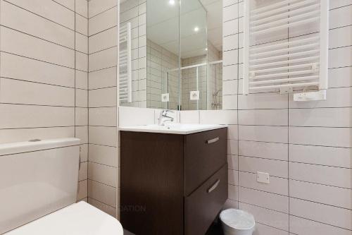 une salle de bain blanche avec un lavabo et un miroir dans l'établissement Residence Aout 22, à Cannes
