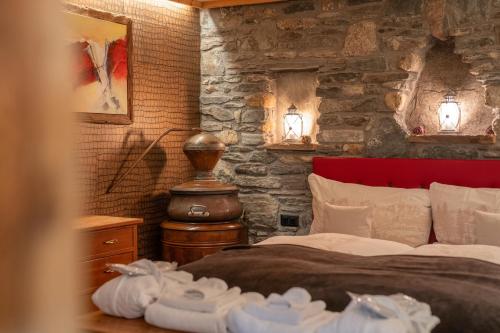 a bedroom with a bed and a stone wall at Schnapskeller in Zermatt