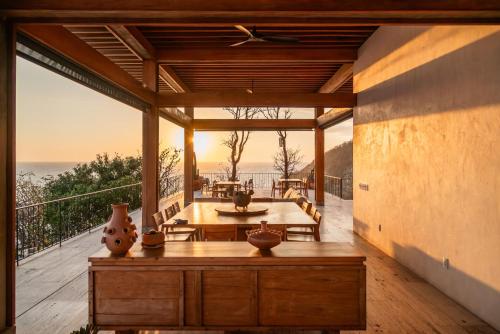 a room with a table and a view of the ocean at La Valise Mazunte, Member of Small Luxury Hotels in Zapotal