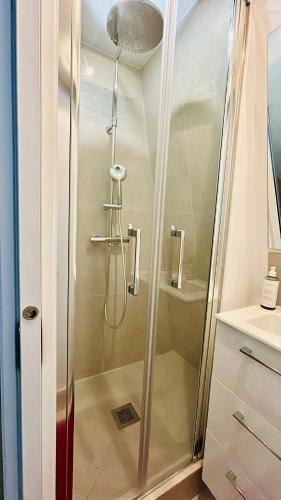 une douche avec une porte vitrée dans une salle de bain dans l'établissement Studio neuf, à Paris