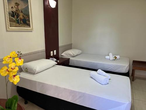 a room with two beds with towels on them at Hotel Alvorada Taguatinga by Bsb Inn in Taguatinga