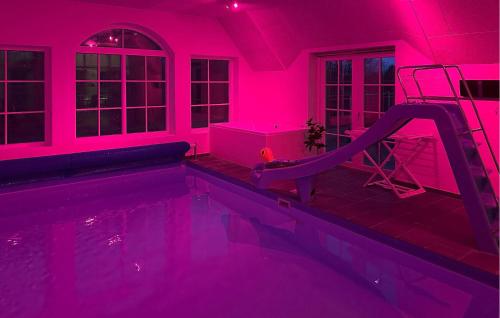 a swimming pool with a slide in a pink room at Stunning Home In Ulfborg With Sauna in Ulfborg