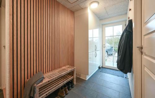 a hallway with a bench and a sliding glass door at Stunning Home In Ulfborg With Sauna in Ulfborg