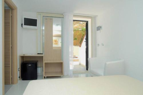 a white room with a bed and a mirror at Residence & Bed e Breakfast AlaMarina in Peschici