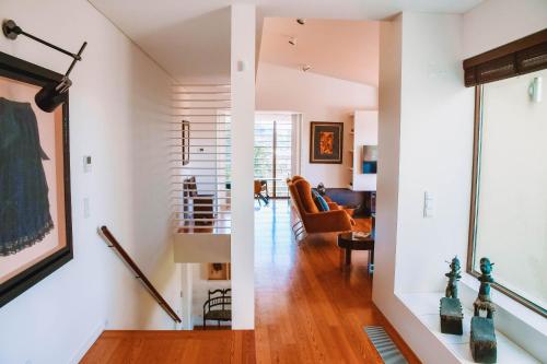 a living room with white walls and wood floors at Just Like Home - Casa do Caracol Horizon Retreat in Viana do Castelo