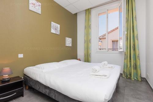 une chambre avec un lit avec deux serviettes dessus dans l'établissement Residence Aout 31, à Cannes