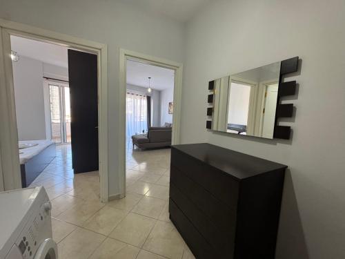 a living room with a black dresser and a mirror at Majd apartment in Vlorë