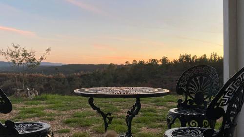 a table and chairs with a view of a field at Vale das Estrelas in São Teotónio