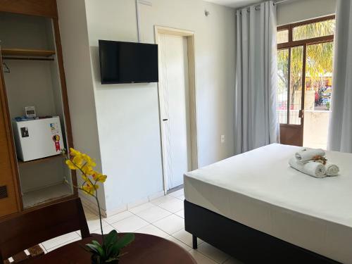a bedroom with a bed with a television on the wall at Hotel Alvorada Taguatinga by Bsb Inn in Taguatinga
