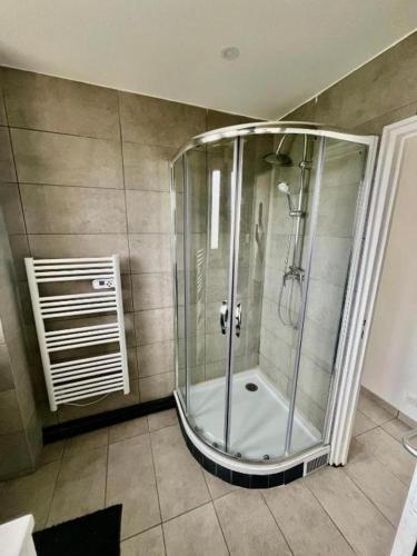 une douche avec une cabine en verre dans une salle de bain dans l'établissement Le KA NOE, à Vaires-sur-Marne