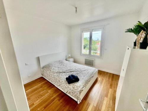 une chambre avec un lit dans une pièce avec une fenêtre dans l'établissement Le KA NOE, à Vaires-sur-Marne