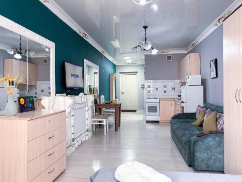 a living room with a couch and a kitchen at Квартира-студия в центре Алматы in Almaty