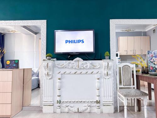 a living room with a tv on a green wall at Квартира-студия в центре Алматы in Almaty