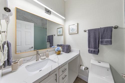 a bathroom with a sink and a large mirror at Ground Floor Beach Side 2Min Walk To The Beach SF in South Padre Island