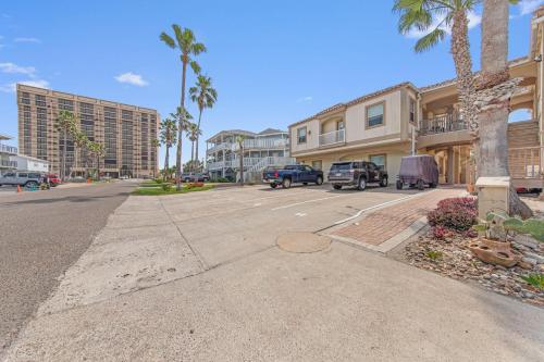 a parking lot at a apartment complex with palm trees at Ground Floor Beach Side 2Min Walk To The Beach SF in South Padre Island