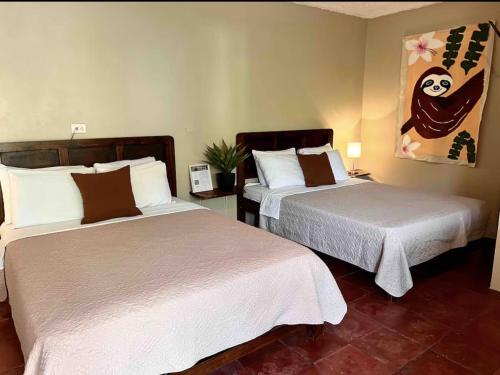 two beds in a hotel room with two beds sidx sidx sidx at Mi Zaru sea view hotel Free MA park tour & breakfast in Manuel Antonio